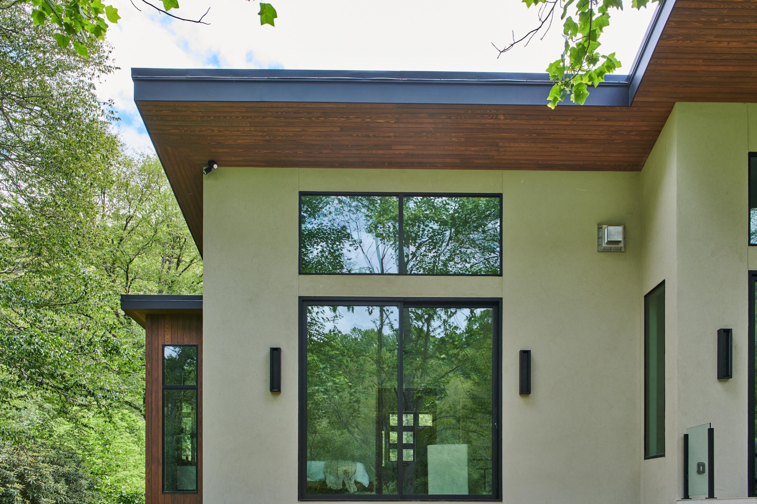 a_house_with_a_large_patio_and_a_large_tree_brdb_highlands_nc_architectural_details